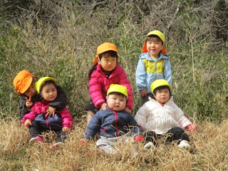 田んぼのあぜでのんびりとしている子どもたち